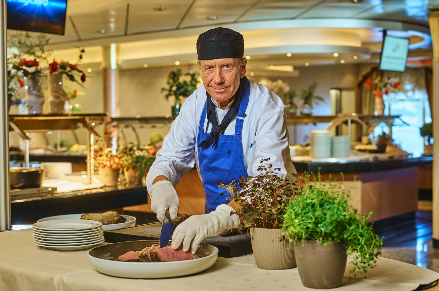 Koch schneidet Fleisch am Buffet auf