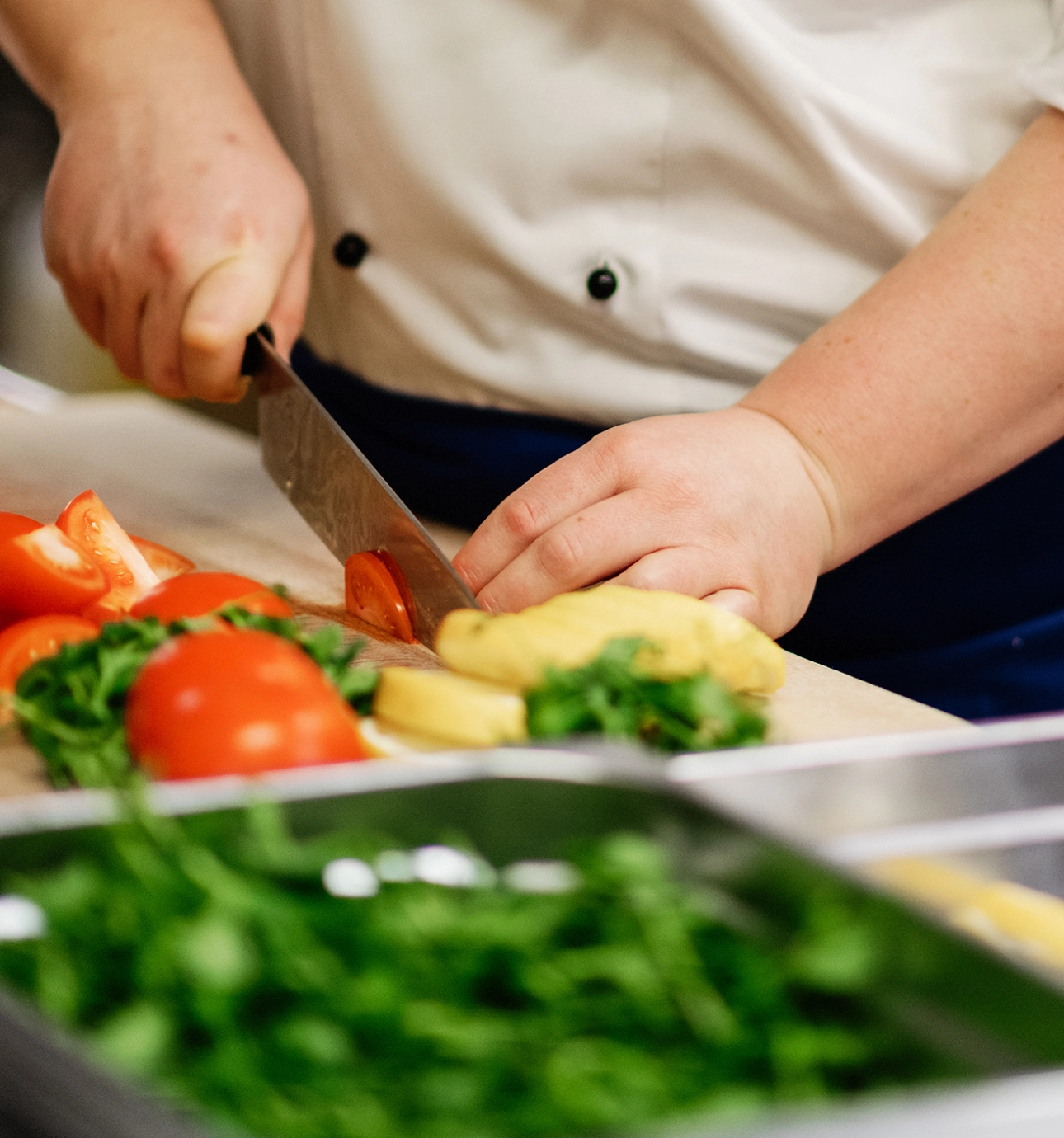 Kokk som kutter tomater